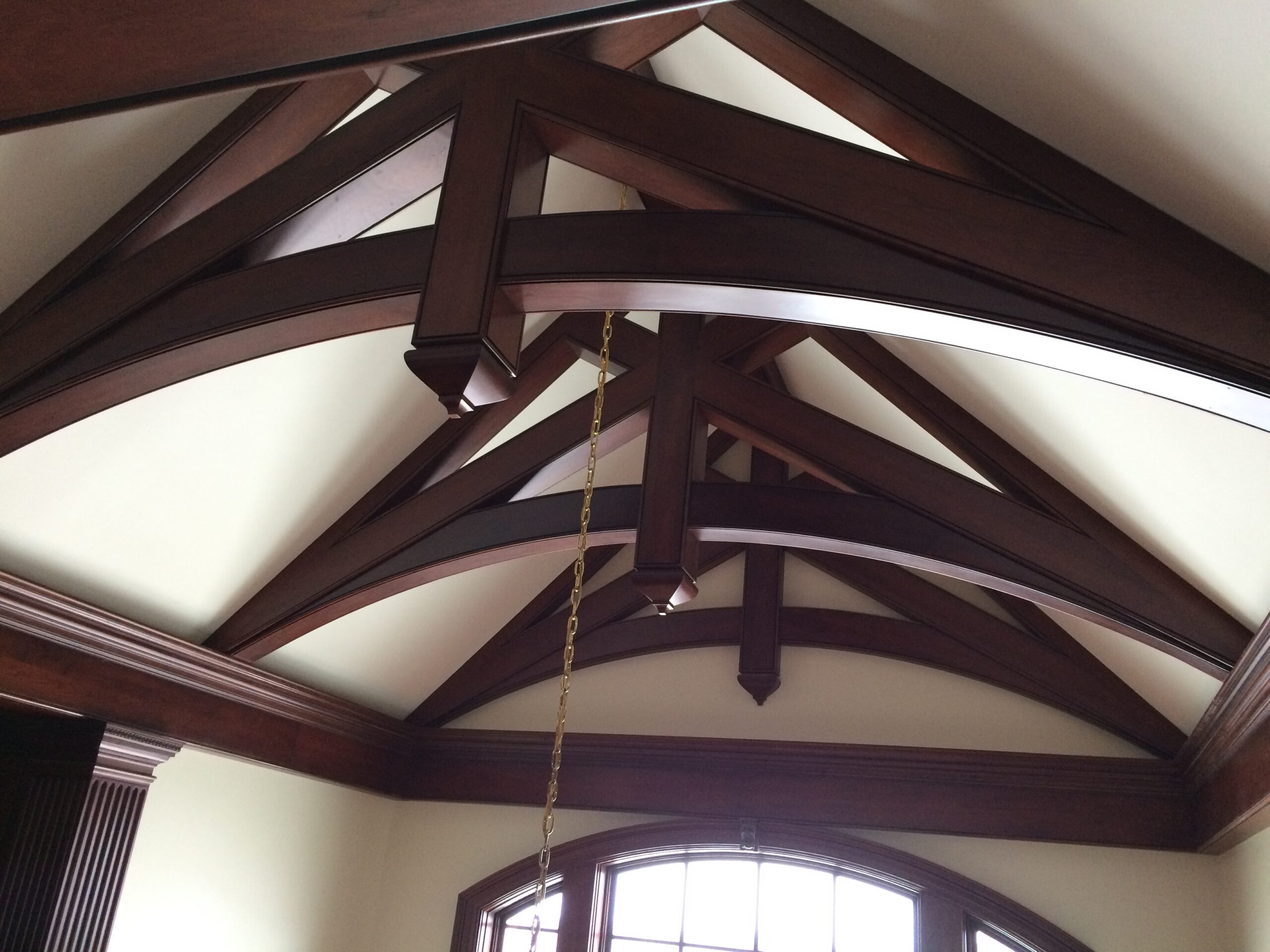Cherry wood truss beams, displaying rich, warm tones and a robust, structural design.